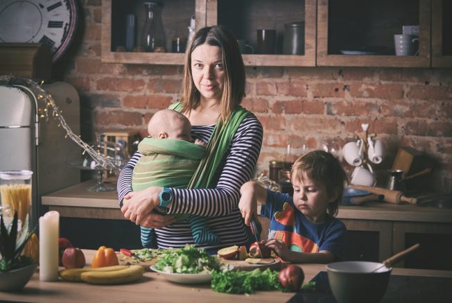 Happy young family in the kitchen preparing a meal.