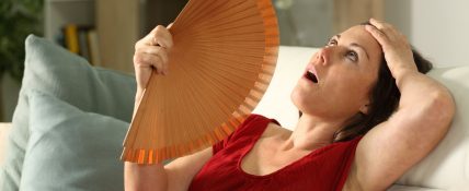 sweating woman fanning herself