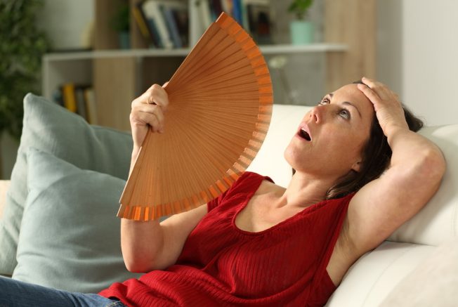 sweating woman fanning herself